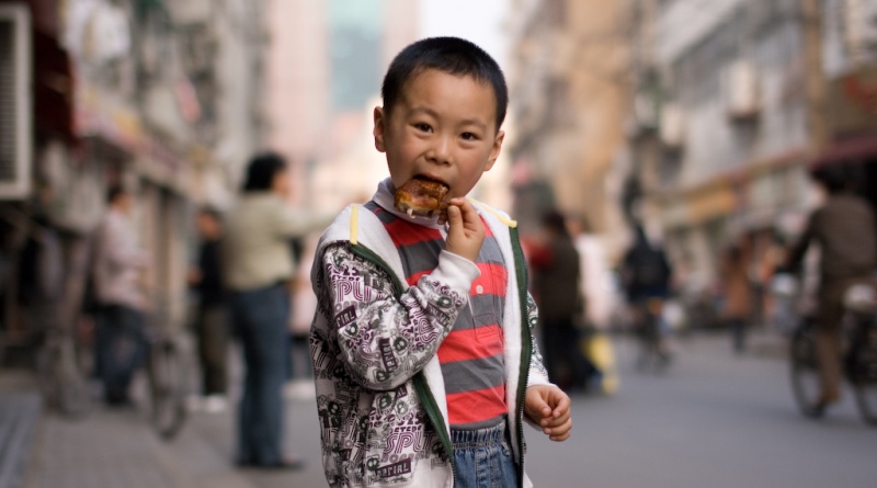 criança comendo carne na china