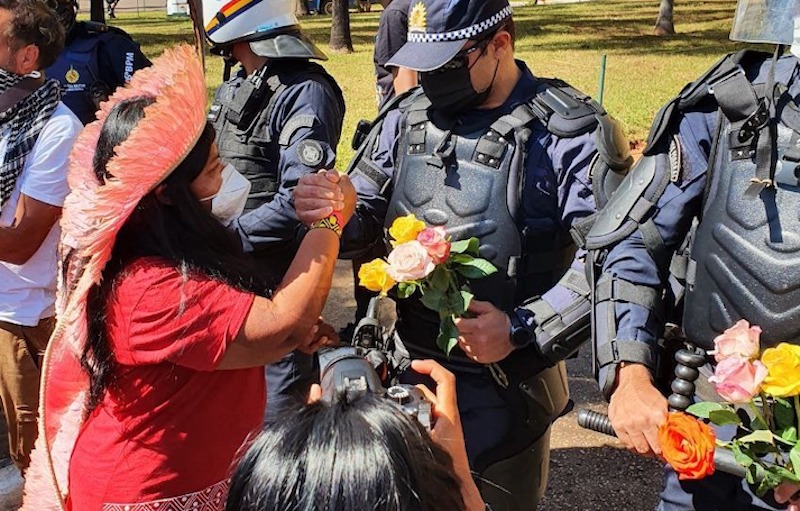 Em ato pacífico pelo arquivamento do PL 490, em frente à Câmara dos Deputados, mulheres indígenas entregam flores para policiais