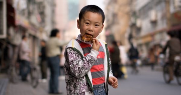 criança comendo carne na china